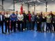 Die Teilnehmer des Lehrgangs auf einem Gruppenbild vor einem Boxring in der Trainingshalle.