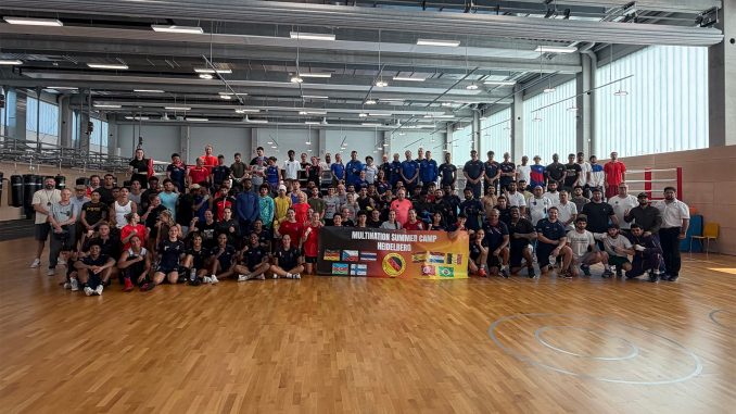 Die Teilnehmerinnen und Teilnehmer des internationalen Sparringslehrgangs 2026 in Heidelberg auf einem Gruppenbild vor den Boxringen.